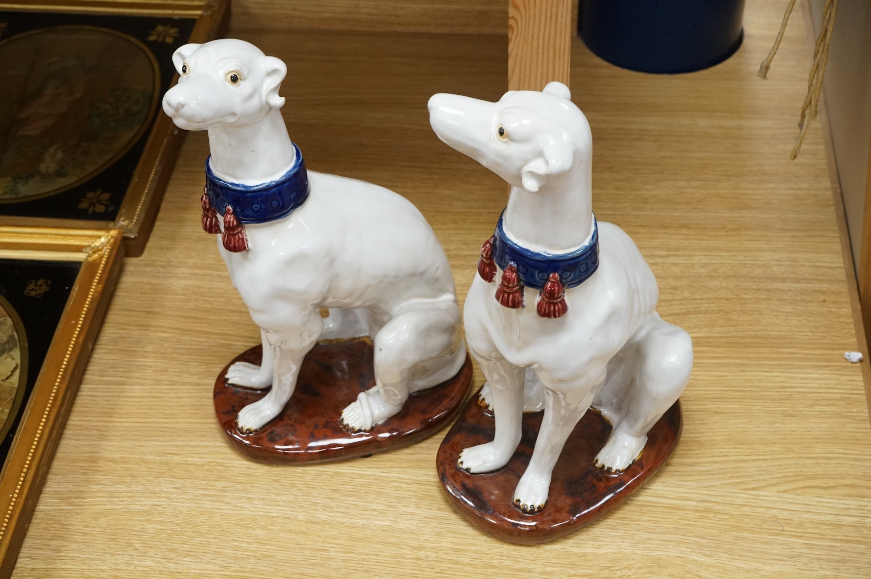 A pair tin glaze models of seated dogs, possibly Greyhounds. 36cm high.